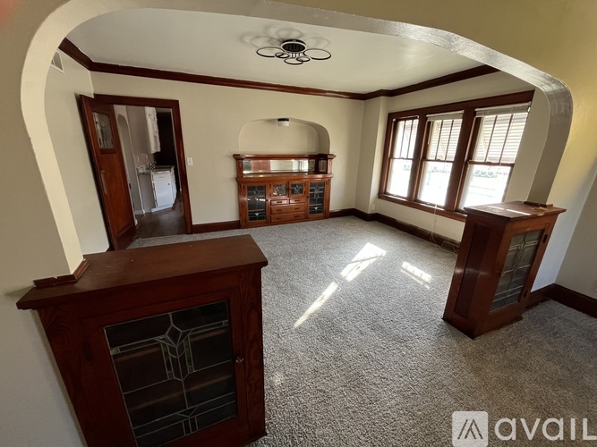 A room with a wooden cabinet and a fan on the ceiling.