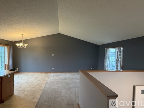 A spacious room with a staircase and a chandelier.