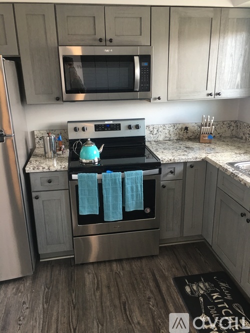 A kitchen with a stove top oven and a microwave above it.