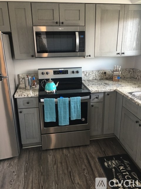 A kitchen with a stove top oven and a microwave above it.