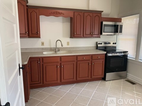 A kitchen with brown cabinets and a stainless steel oven.