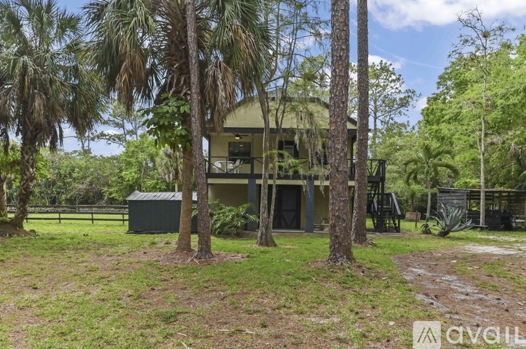A house surrounded by trees in a grassy area.