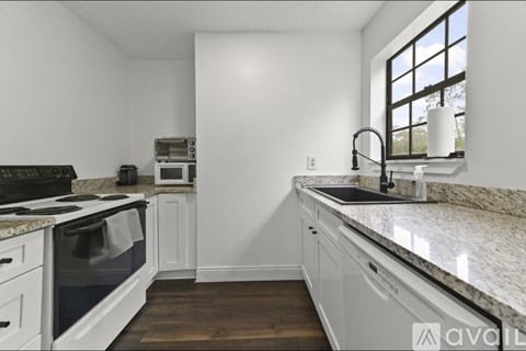 A kitchen with a granite countertop and white cabinets.