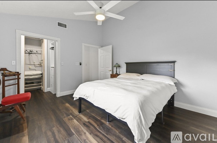 A bedroom with a large bed and a ceiling fan.