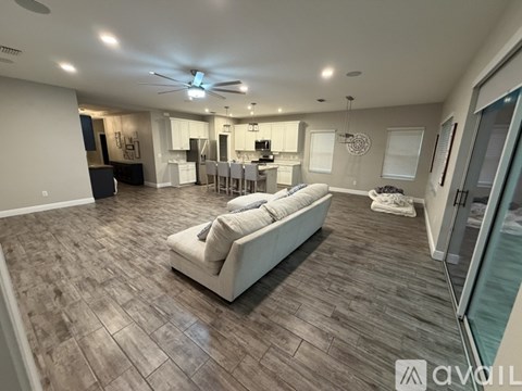 A living room with a white couch and a ceiling fan.