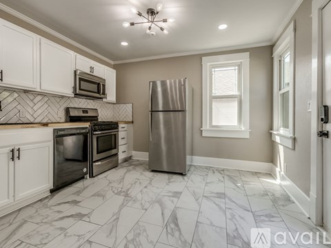 A kitchen with a refrigerator, microwave, oven, and cabinets.