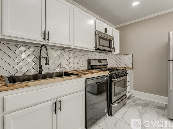 A kitchen with white cabinets and a black stove top oven.