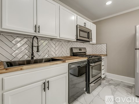 A kitchen with white cabinets and a black stove top oven.