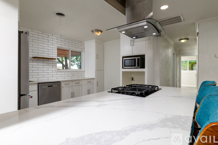 A modern kitchen with a white countertop and a microwave above it.