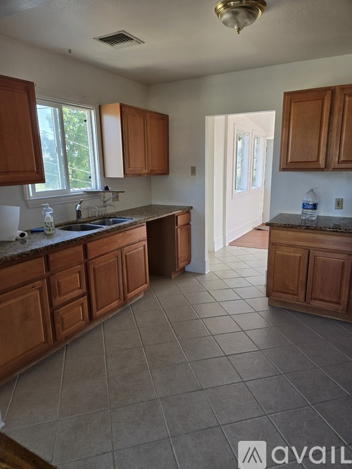 A kitchen with wooden cabinets and a tiled floor.