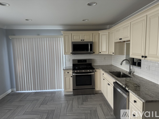 A kitchen with a sink, stove, and microwave.
