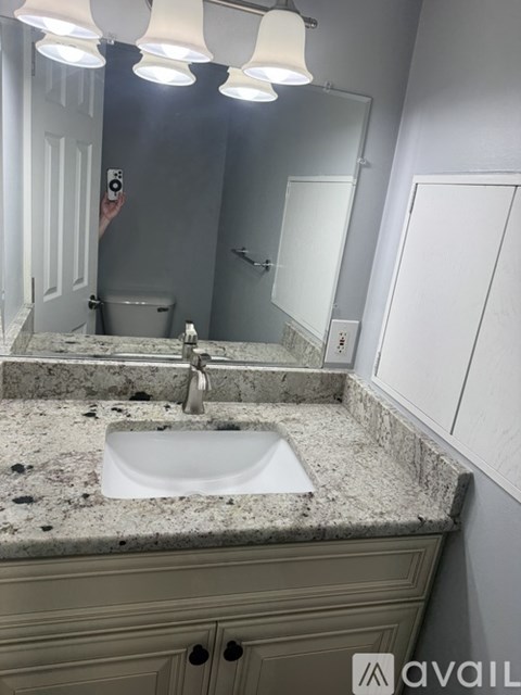 A bathroom with a granite countertop and a sink.