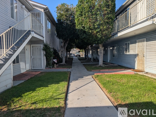 A row of houses with a sidewalk in front.