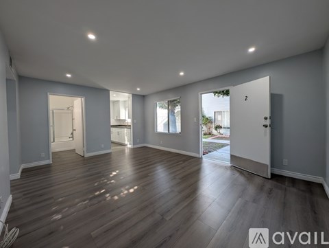A spacious room with wooden floors and white walls.