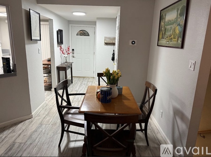 A dining room with a wooden table and chairs.