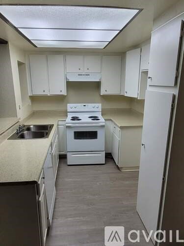 A kitchen with white appliances and cabinets.