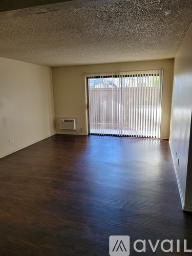 A room with a window covered by blinds and a wall-mounted air conditioner unit.