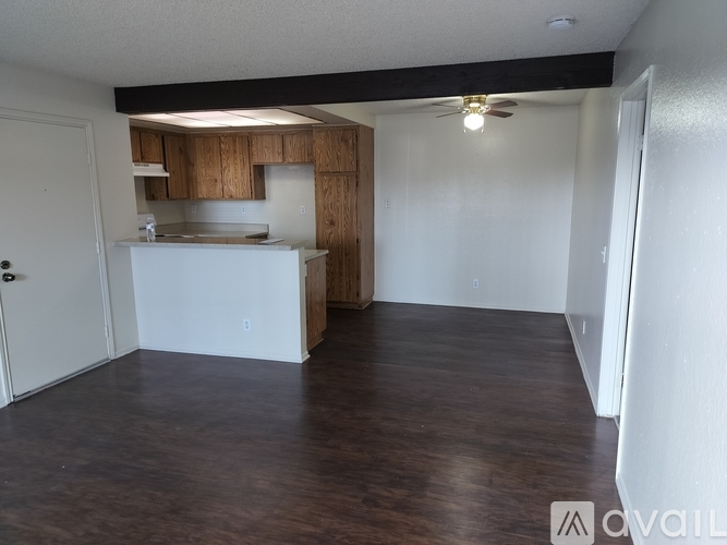 A kitchen area with wooden cabinets and a white countertop.