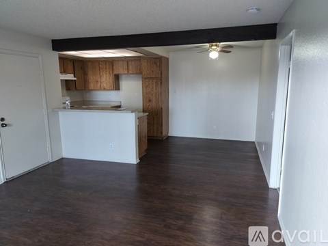 A kitchen area with wooden cabinets and a white countertop.