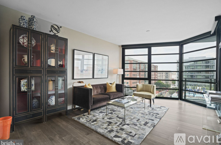 A living room with a black sofa and a glass cabinet.