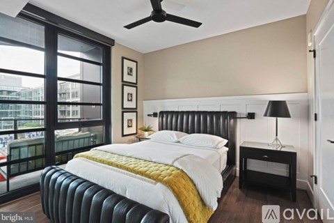 A bedroom with a large bed and a balcony overlooking the city.