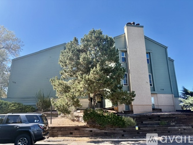 A grey building with a tree in front of it.