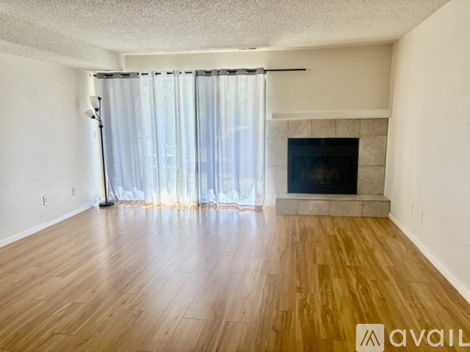 A living room with a fireplace and a sliding glass door.