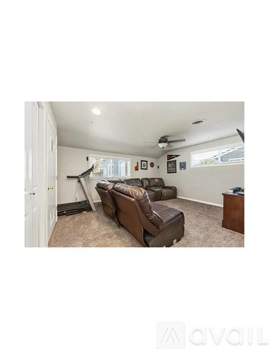 A living room with a brown couch and a white door.