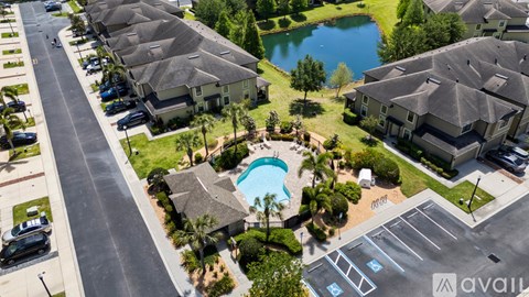 A bird's eye view of a residential area with houses, a swimming pool, and a parking lot.