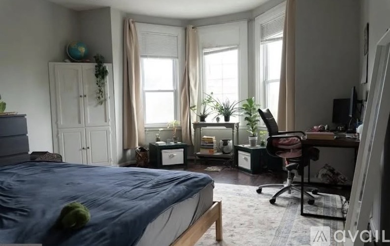 A bedroom with a bed, desk, and chair.