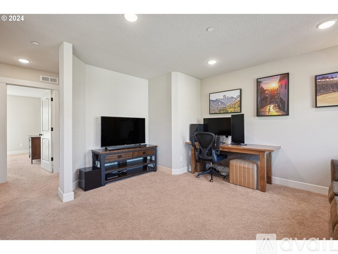 A living room with a television and a desk with a computer.
