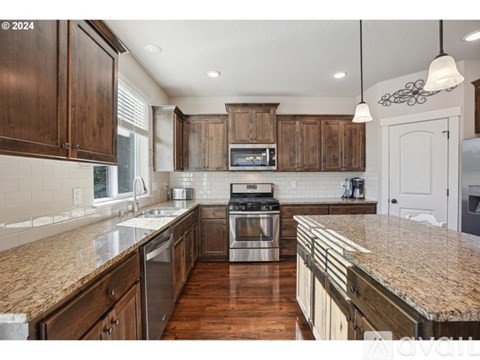 A kitchen with wooden cabinets and granite countertops.