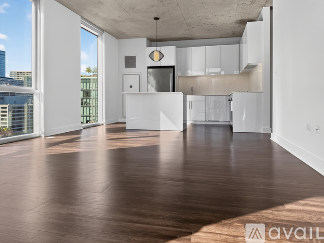 A spacious, empty room with wooden floors and white walls.