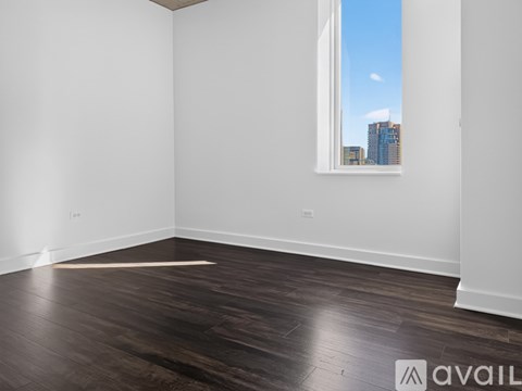 A room with a large window and wooden flooring.