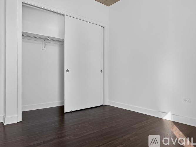 A white door is in a room with wooden floors.