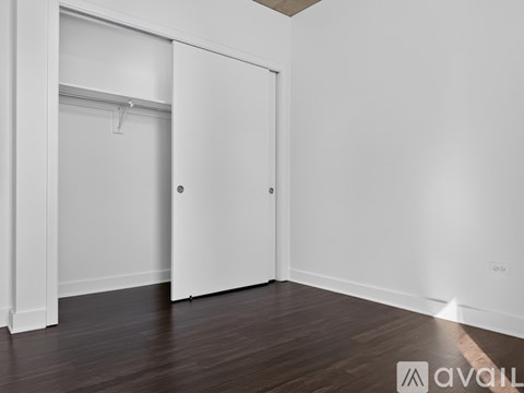 A white door is in a room with wooden floors.