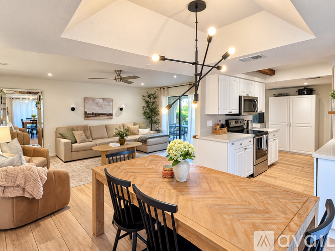 A modern kitchen with white cabinets and a wooden table.