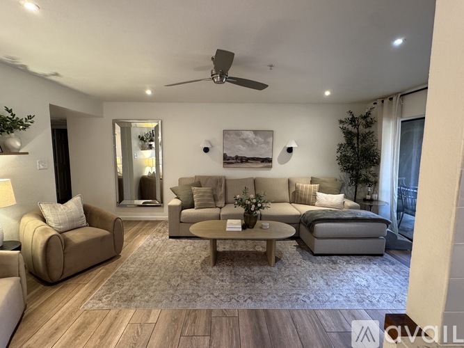 A living room with a beige sofa, a coffee table, and a painting on the wall.