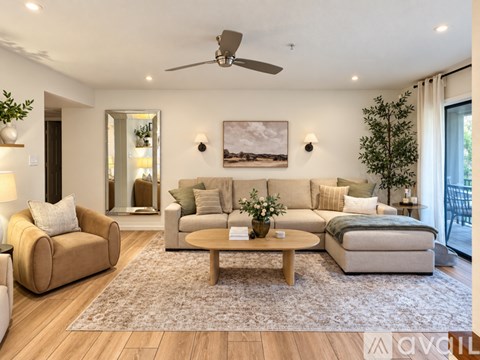 A living room with a beige sofa, a coffee table, and a painting on the wall.
