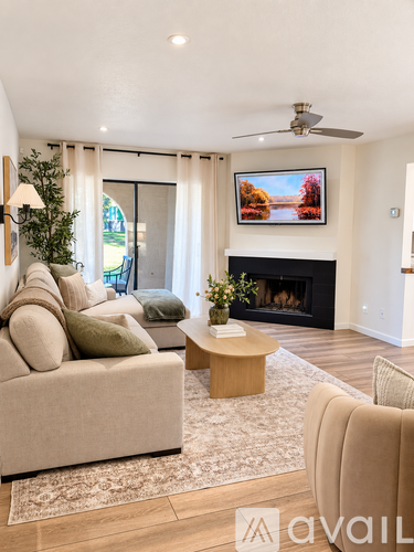 A living room with a beige couch, a coffee table, and a fireplace.