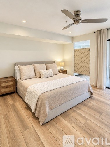 A bedroom with a large bed and a ceiling fan.