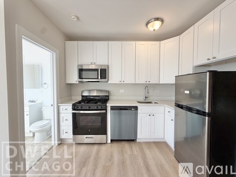 A kitchen with white cabinets and stainless steel appliances.