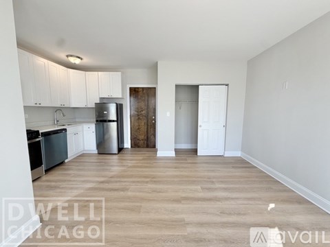 A kitchen with white cabinets and a wooden door.