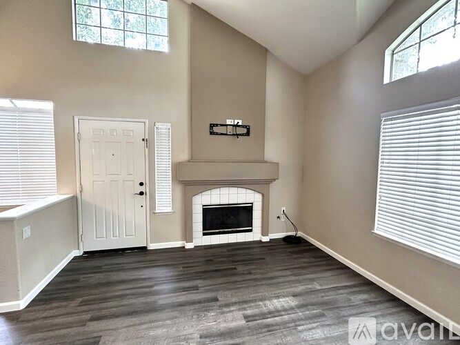A living room with a fireplace and a television on the wall.