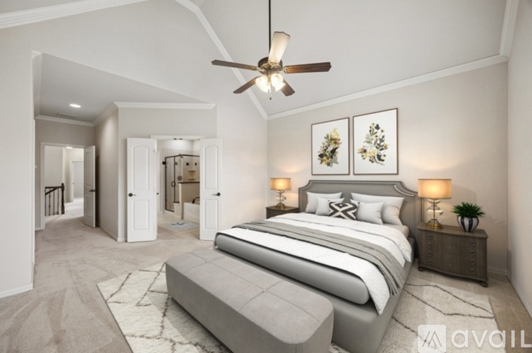 A bedroom with a large bed and a ceiling fan.