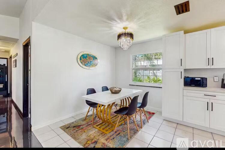 A dining room with a white table and chairs.