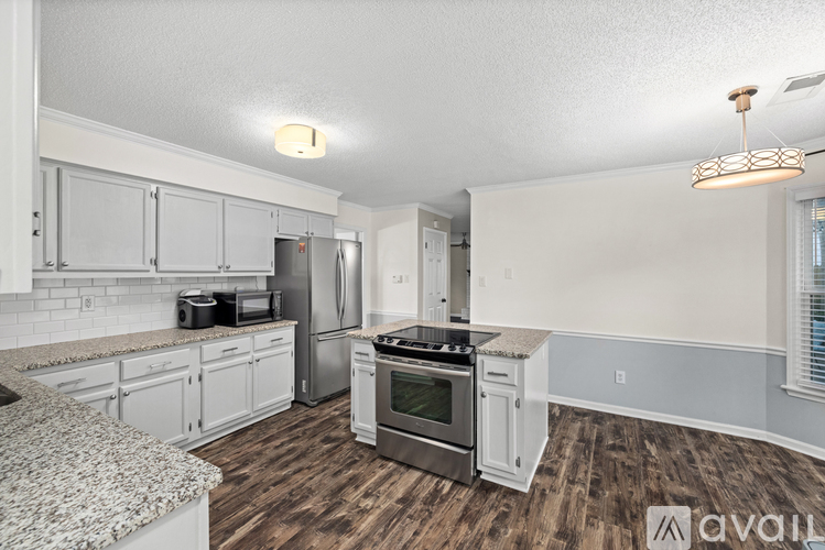 A kitchen with white cabinets and a granite counter top.