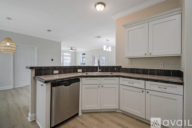 A kitchen with white cabinets and a black countertop.