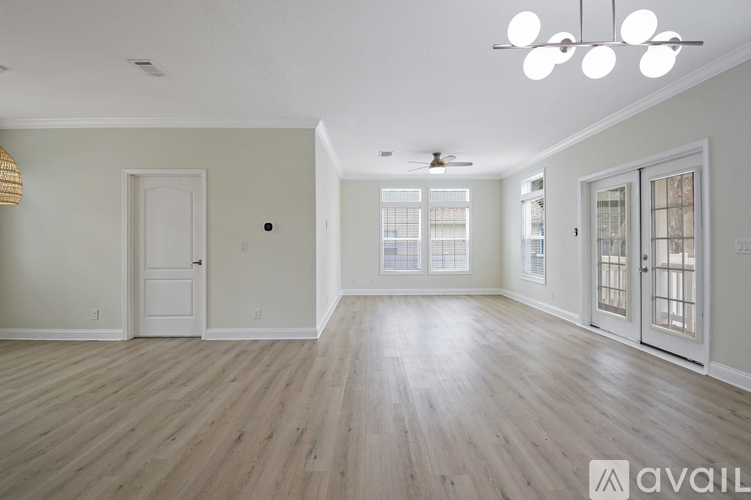 A spacious room with wooden floors and white walls.