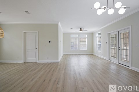 A spacious room with wooden floors and white walls.